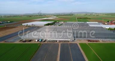 现代化的大型温室，一个大型的农业综合体，飞过绿茵场环绕的温室